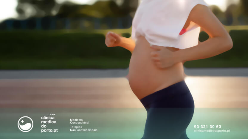 Imagem de mulher grávida numa pista de atletismo a correr