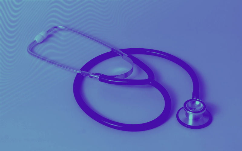 Imagem de um estetoscopio médico em cima de uma secretaria - alusivo a uma consulta médica