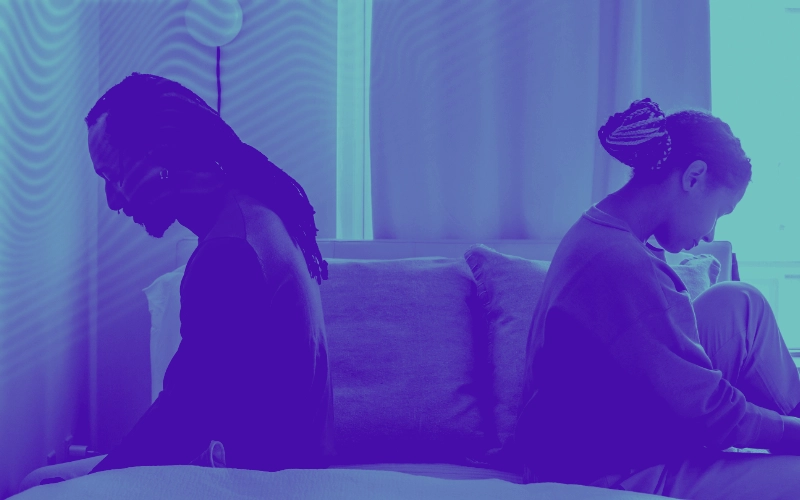 Imagem de um casal sentado na cama de costas voltadas, significando ruptura ou desentendimento, clivagem do casal