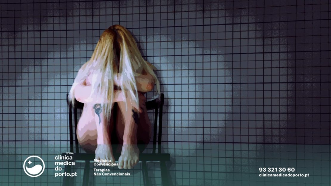 Imagem de mulher em cima de cadeira em posição fetal com mãos no rosto simbolizmo de sofrimento ou dor